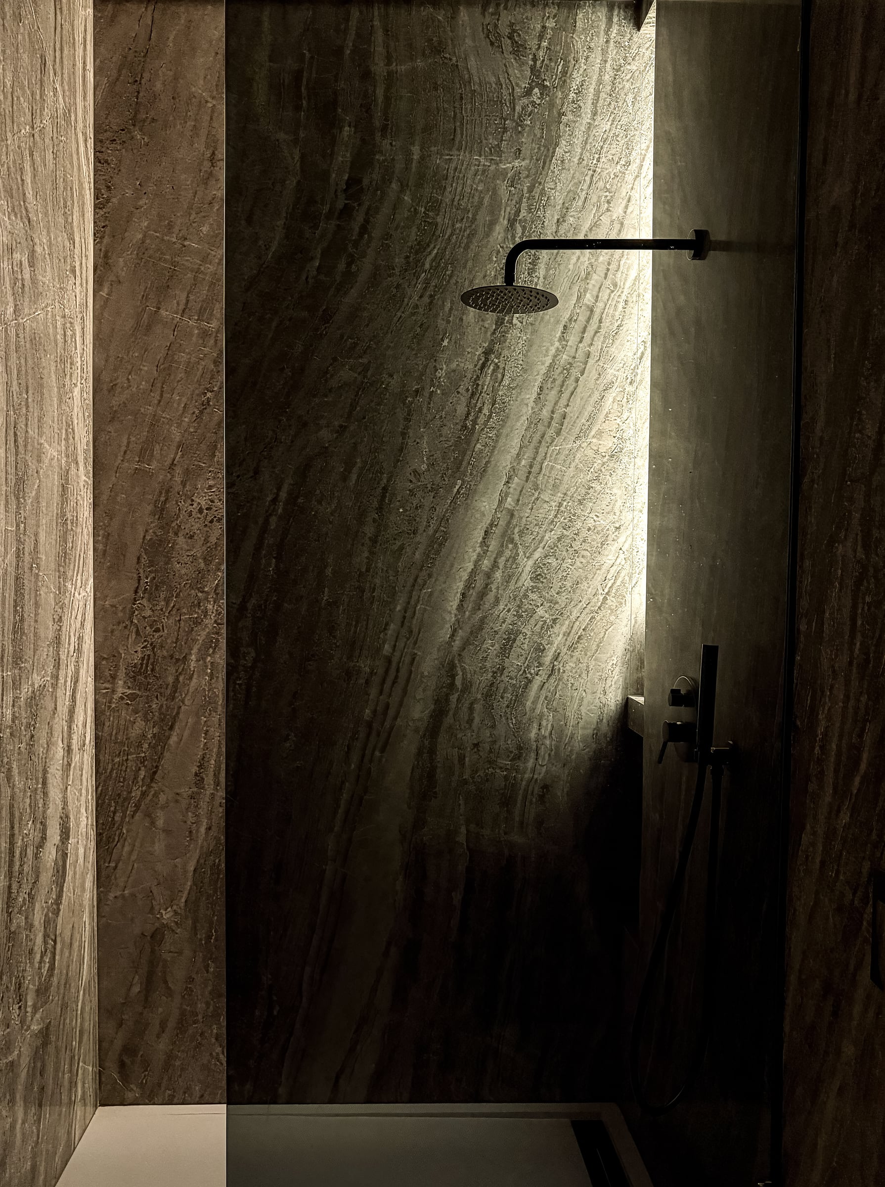 Black marble shower with integrated LED lighting